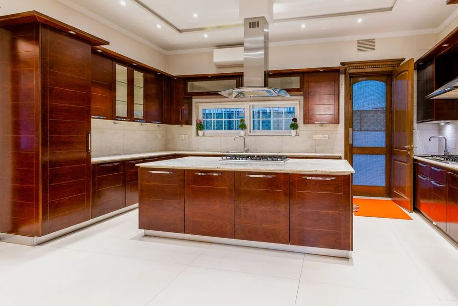 Covered with sheet sofa and floor lamp and packed cardboard boxes in a bright, airy room of a modern new house
