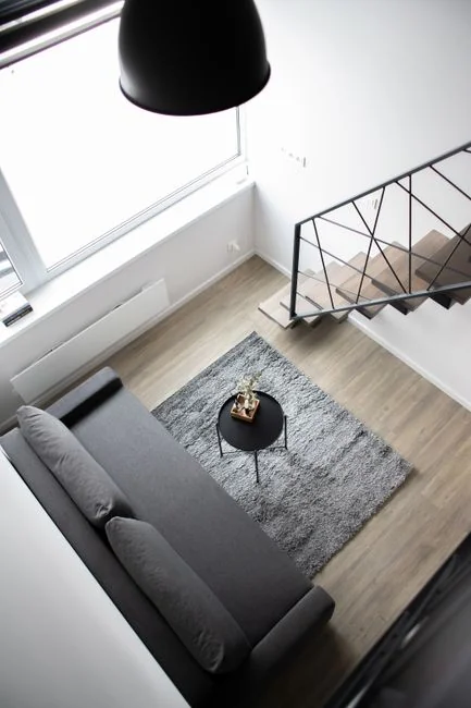 Happy couple setting up a sofa in their new home surrounded by moving boxes.